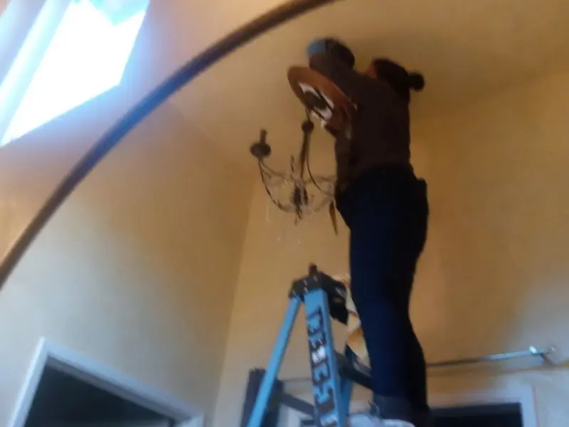 Electrician installing a chandelier in a West Lealman residence